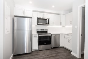 a kitchen with stainless steel appliances and white cabinets
