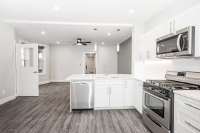 a kitchen with white cabinets and stainless steel appliances