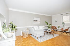 A living room with a white couch, a brown chair, and a white cabinet.
