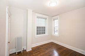 A room with a window and a radiator on the floor.