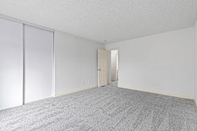 A room with a carpeted floor and a sliding door at Stony Creek Apartments, Santa Rosa, California