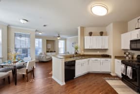 a kitchen and living room with hardwood floors and white cabinets