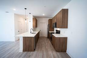 A modern kitchen with wooden cabinets and a white countertop.
