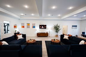 A living room with dark blue couches and a wooden coffee table.