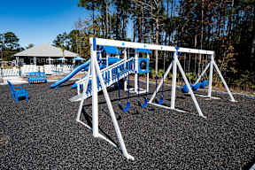 A playground with a blue slide and white structure.
