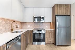 A modern kitchen with a stainless steel refrigerator and a double oven.