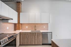 A kitchen with a stove top oven and a refrigerator.