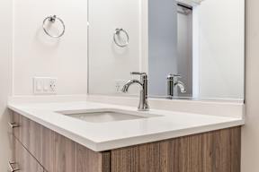 A modern bathroom with a white sink and a mirror.