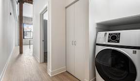 A washing machine is sitting in a laundry room.