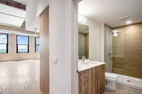 A bathroom with a toilet, sink, and a window.