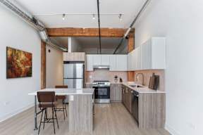A kitchen with a table and chairs in front of it.