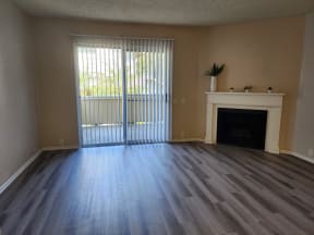 an empty living room with a fireplace and a sliding glass door