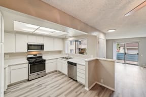 a kitchen with white cabinets and stainless steel appliances