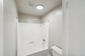 a white bathroom with a shower and a toilet