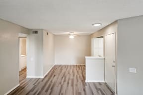 an empty living room with wood flooring and white walls