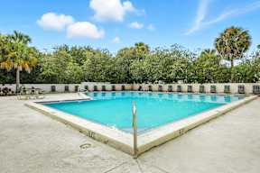 A rectangular pool with a white fence around it.