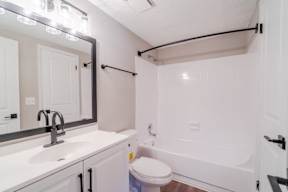 A white bathroom with a sink, toilet, and bathtub.