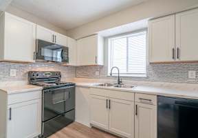 A kitchen with a black oven and white cabinets.