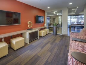 a room with couches and chairs and a television on the wall