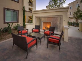 a patio with a fire place and chairs