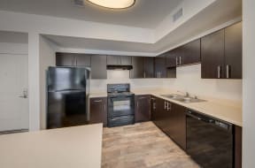 a kitchen with dark wood cabinets and stainless steel appliances