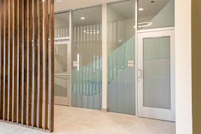 A glass door with a white frame and a wooden panel on the left side.