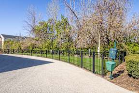 A black fence surrounds a green mailbox.