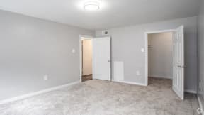 an empty living room with an open door to a bedroom