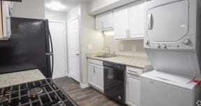 a white and black kitchen with a washer and dryer