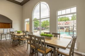 a dining area with tables and chairs and large windows