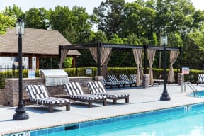 a swimming pool with chaise lounge chairs and a hot tub