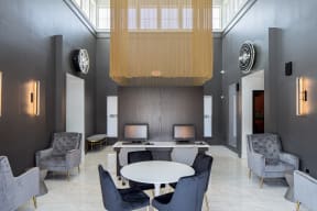a large room with a round table with chairs and a chandelier above it