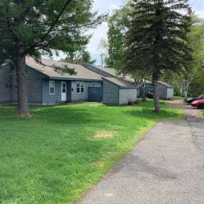 a blue house with a sidewalk and some trees