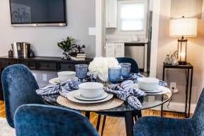 a dining room table with blue chairs and a glass table top