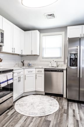 a kitchen with white cabinets and stainless steel appliances
