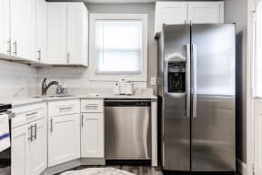 a kitchen with white cabinets and stainless steel appliances