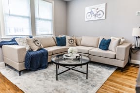 a living room with couches and a coffee table in front of a window