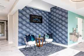 A wall with a pattern of blue hexagons with a black sign on it.