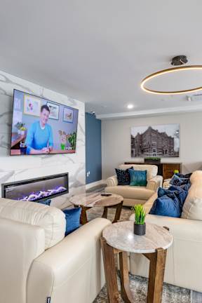 A living room with a fireplace and a television on the wall.