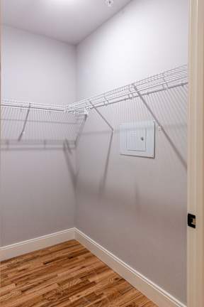 A white wall with a white door and a white electrical outlet.