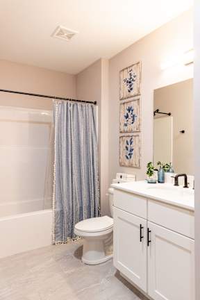 A bathroom with a toilet, sink, and shower.