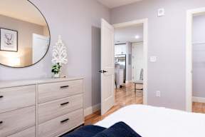 A bedroom with a bed, dresser, and mirror.