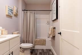 A bathroom with a toilet, sink, and shower.