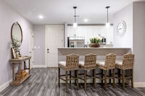 A kitchen with a dining table and chairs.