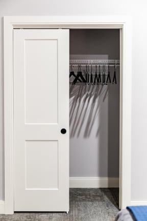 a closet with a white door and grey walls