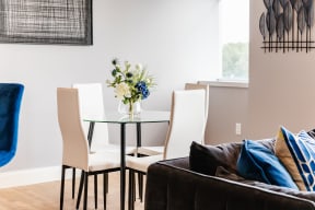 a dining room with a glass table and white chairs
