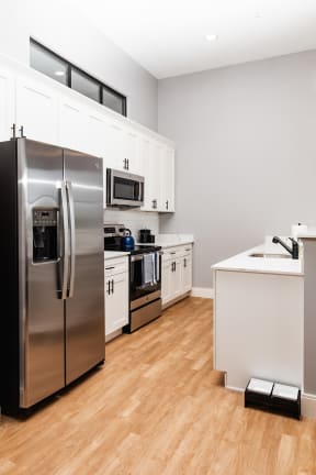 a kitchen with white cabinets and stainless steel appliances
