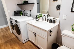 a bathroom with a washer and dryer and a sink