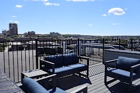 A patio with a table and chairs overlooking a city.