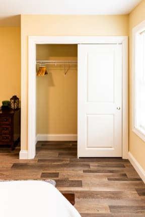 a closet with a white door and yellow walls